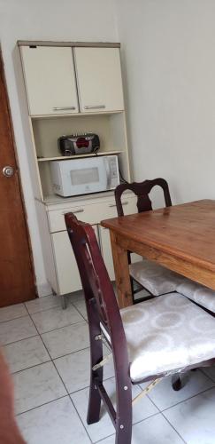 a table and a chair with a table and a microwave at APARTAMENTO céntrico Para 5 PERSONAS in Paysandú