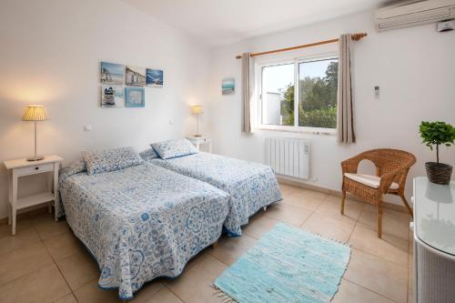 a bedroom with two beds and a window at Casa Madrugada in Carvoeiro
