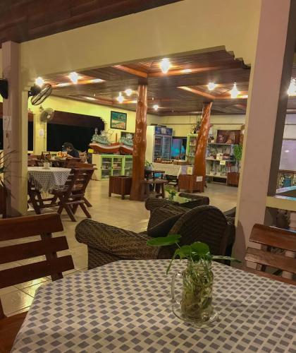 a dining room with a table with a vase on it at Tanouy Garden in Baan Khai