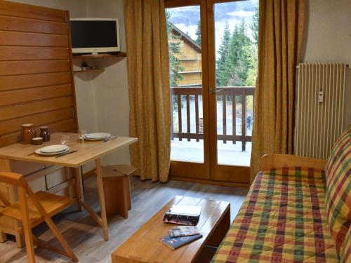 d'un salon avec une table et d'une chambre avec un balcon. dans l'établissement Studio cosy avec balcon, proche des pistes et commerces - Méribel - FR-1-180-567, à Les Allues