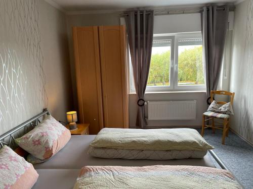 1 dormitorio con 2 camas y ventana en Petryhof, en Mörsdorf