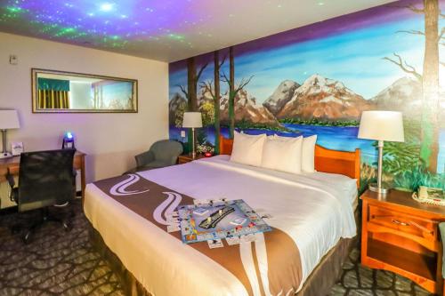 史魁恩的住宿－Quality Inn & Suites Sequim at Olympic National Park，酒店客房的墙上设有一张带绘画的床铺。