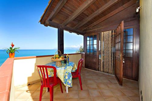 a table and chairs on a balcony with the ocean at Blunda Holiday Home in Castellammare del Golfo