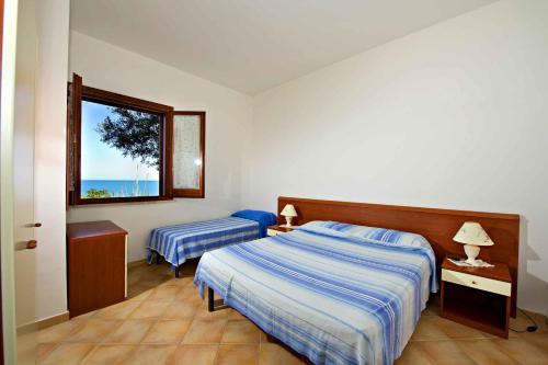 a hotel room with two beds and a window at Blunda Holiday Home in Castellammare del Golfo