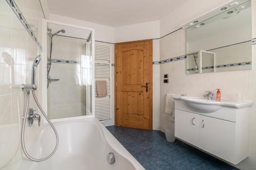 a bathroom with a tub and a sink and a shower at Gruberhof Coll in Funes