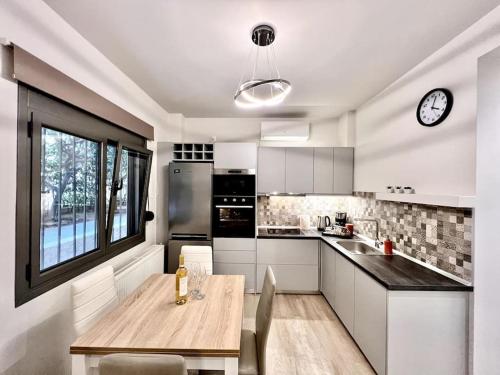 a kitchen with a wooden table and a clock on the wall at Lovely 1-Bedroom 2 minutes from Beach in Athens