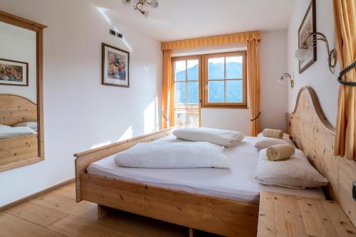 a bedroom with two beds and a large window at Gruberhof Coll in Funes