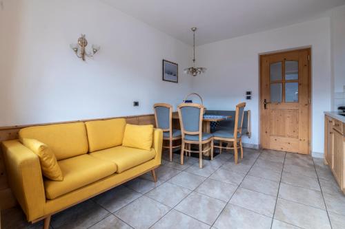 a living room with a yellow couch and a table at Gruberhof Coll in Funes