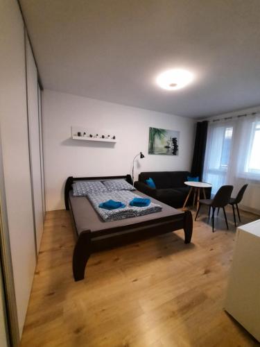 a bedroom with a bed and a living room at Apartment Klimka with balcony and free parking in Bratislava