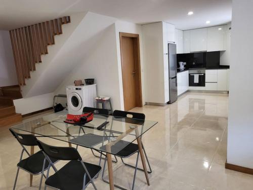 cocina con mesa de cristal y sillas en una habitación en Maison Fernandes, 