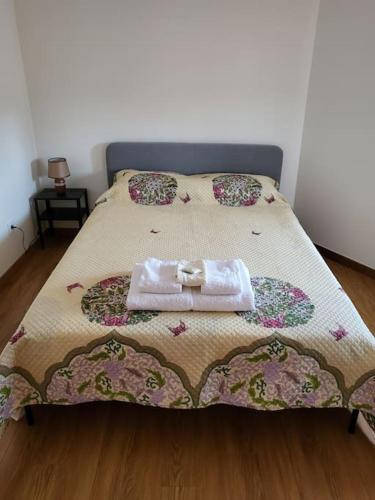 a bed with a blanket and a towel on it at Maison Fernandes in Bustelo