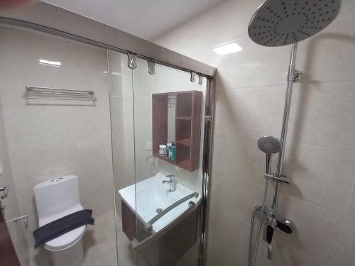 a bathroom with a shower and a toilet and a sink at Leon's Den in Baguio