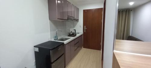 a small kitchen with a sink and wooden cabinets at Leon's Den in Baguio