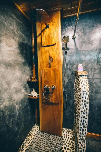 a bathroom with a wooden door in a room at Andalay Beach Resort Koh Libong in Ko Libong