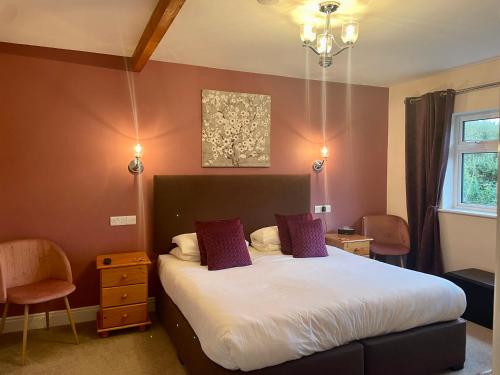 a bedroom with a large bed with purple pillows at Buttermilk Lodge Guest Accommodation in Clifden