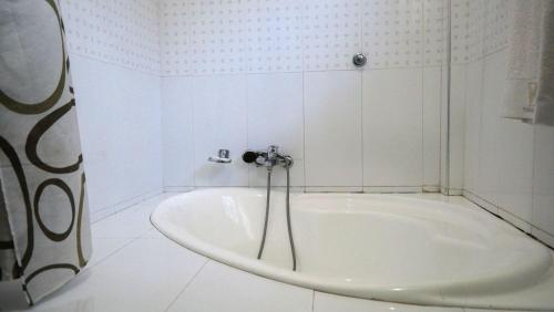 a bath tub in a bathroom with a shower at Yakam Hotel Limited in Kintampo