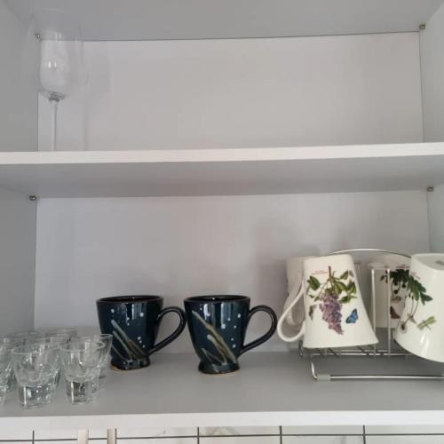 a shelf with three coffee cups and glasses on it at Yeonriji in Gyeongju