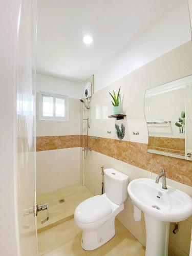a bathroom with a toilet and a sink at Kabansoy Haven in Moalboal