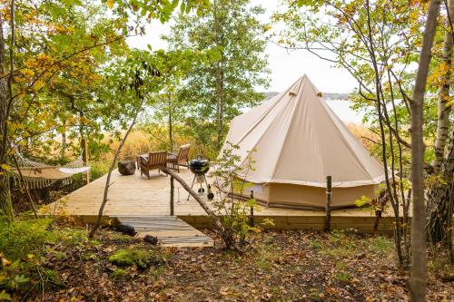 a tent on a wooden boardwalk in the woods at Surfviken Glamping and B&B in Stenungsund