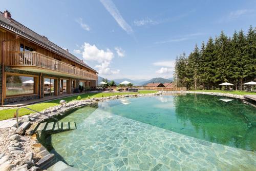 a large swimming pool in front of a building at Lerchpeuntgut Alpenfreud Chalets in Tamsweg