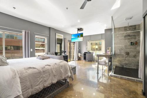 a bedroom with a bed and a shower and a television at Good Hotels Downtown Denver in Denver