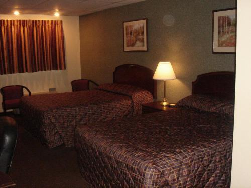a hotel room with two beds and a lamp at German Village Inn Motel in Columbus