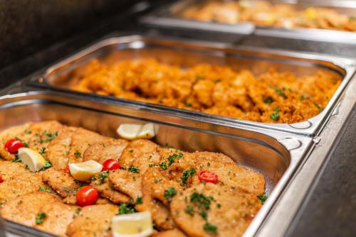 two metal trays of food in a buffet at Hotel Adapura Wagrain in Wagrain