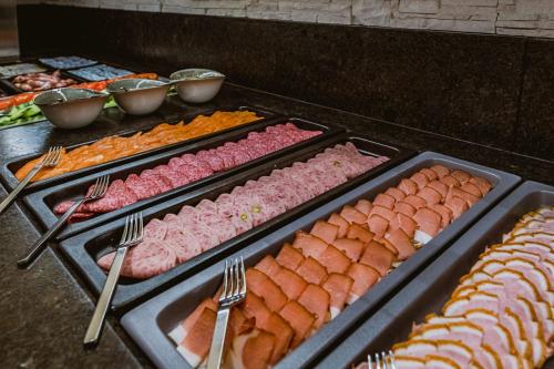 a buffet with several trays of different types of food at Hotel Adapura Wagrain in Wagrain