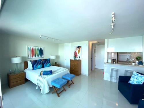a bedroom with a bed and a couch and a kitchen at KASA Terrace Studio Breathtaking Ocean Views in San Juan