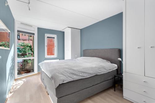 - une chambre avec un lit et un mur bleu dans l'établissement Keybutler Central Apartment Grønland, à Oslo
