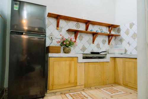 a kitchen with a stainless steel refrigerator and wooden cabinets at Hanoi Hola House in Hanoi