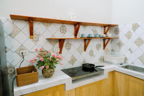 a kitchen with a vase of flowers on a counter at Hanoi Hola House in Hanoi
