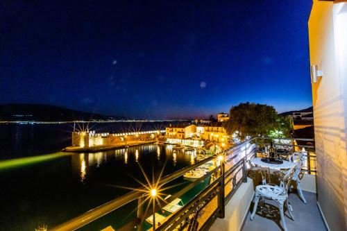 a balcony with a view of a marina at night at Vip Lepanto Port Suites in Nafpaktos