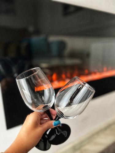 a person holding two wine glasses in their hand at Dis Delux in Kruševac