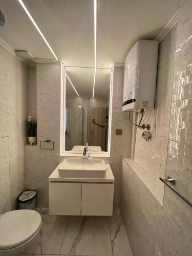 a bathroom with a sink and a toilet and a mirror at Dis Delux in Kruševac