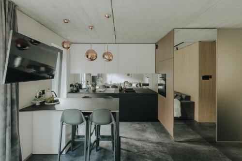a kitchen with a counter and two stools at Apartamenty HEYER in Łódź