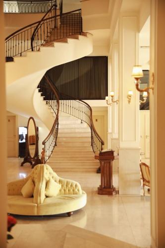 a spiral staircase in a living room with a bed on the floor at Hotel Garden in Pristina
