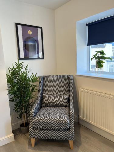 a living room with a chair and a window at 20 Coop Street Apartments in Blackpool