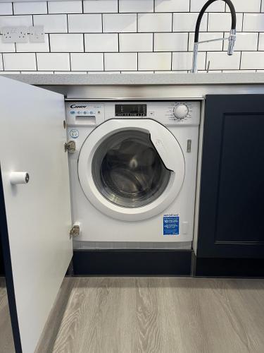 a washing machine in a kitchen next to a counter at 20 Coop Street Apartments in Blackpool