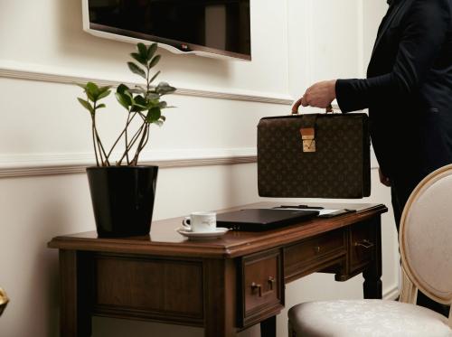 una persona con un maletín en un escritorio con un ordenador portátil en Hotel Garden, en Pristina