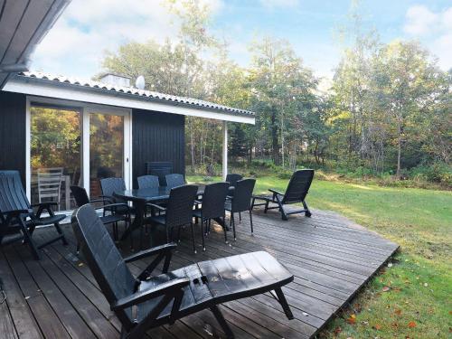 eine Terrasse mit einem Tisch und Stühlen auf einer Terrasse in der Unterkunft 8 person holiday home in Roslev in Glyngøre