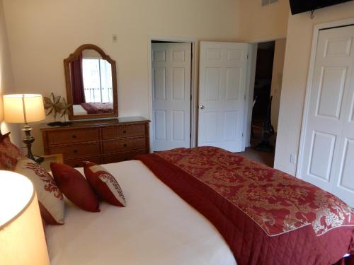 a bedroom with a large bed and a mirror at Bahama Bay in Kissimmee