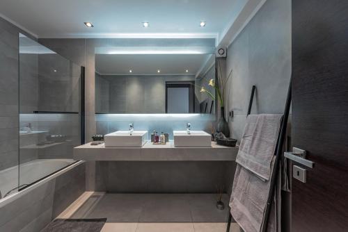 La salle de bains est pourvue de 2 lavabos et d'une baignoire. dans l'établissement Villa Soligia, à Pefkali