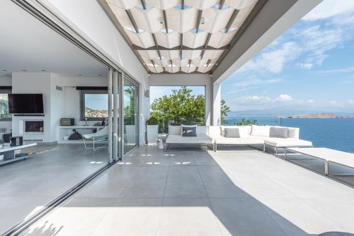 an open living room with a view of the ocean at Villa Soligia Blue in Pefkali