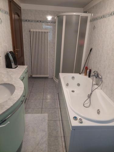 a bathroom with a shower and a tub and a sink at Maison Magicien in Oyace