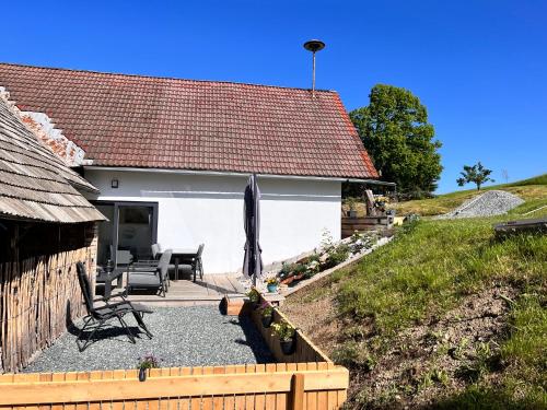 a cottage with a patio with a table and chairs at Haus Tilia Karinthië Appartementen in Nötsch