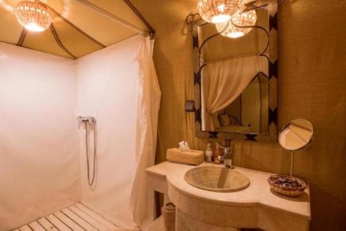 a bathroom with a sink and a shower and a tub at Erg Chebbi Camp in Merzouga