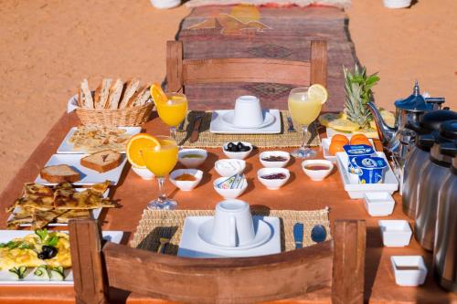 een tafel met ontbijtproducten en drankjes erop bij Erg Chebbi Camp in Merzouga