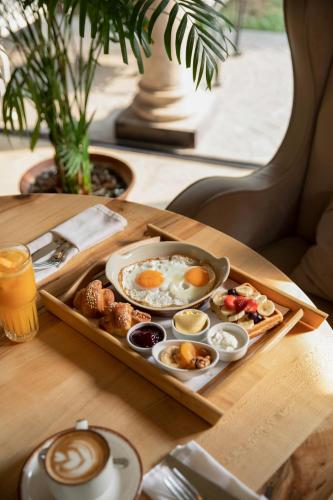 a tray of eggs and other breakfast foods on a table at Hotel Garden in Pristina