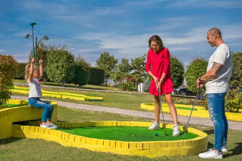 a man and a woman playing golf with a little girl at Park & Spa Hotel Markovo in Plovdiv
